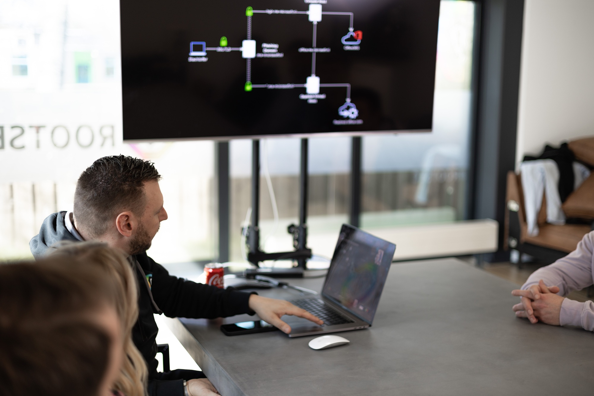 Rootsec team reviewing a network topology diagram on a wall screen