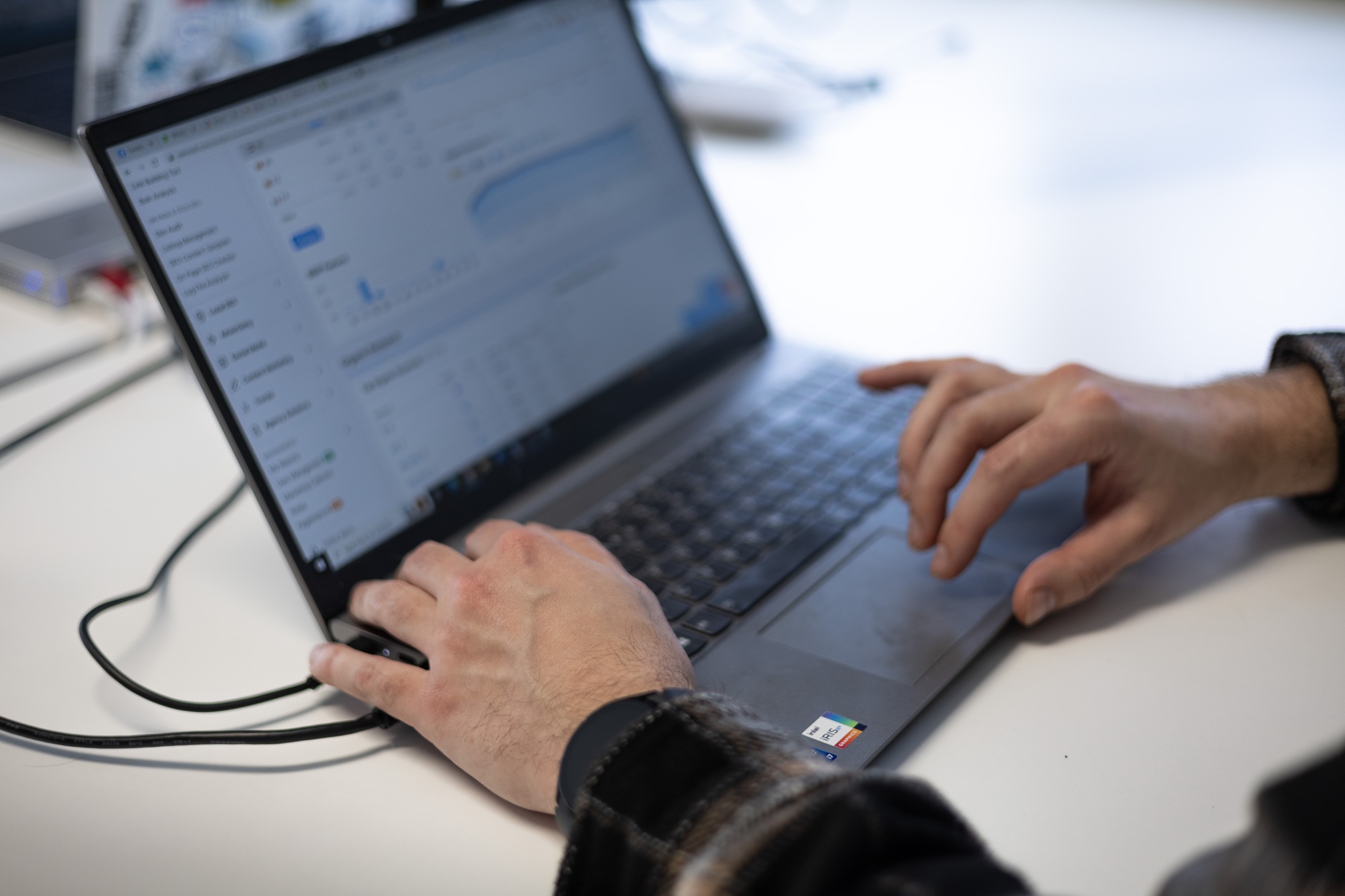 Close-up of hands working on a laptop showing a security assessment dashboard