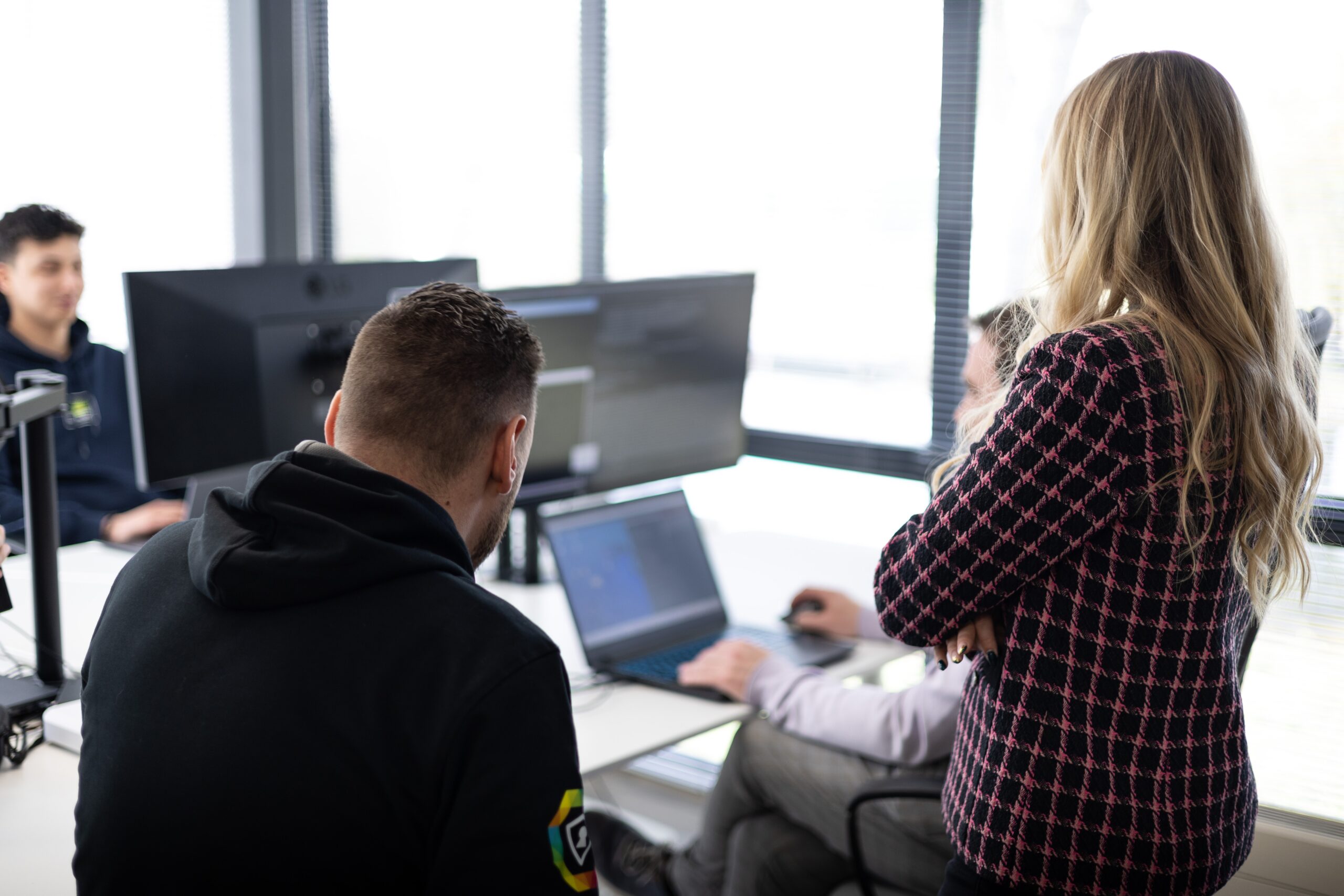 Rootsec colleagues gathered around a laptop during a working session