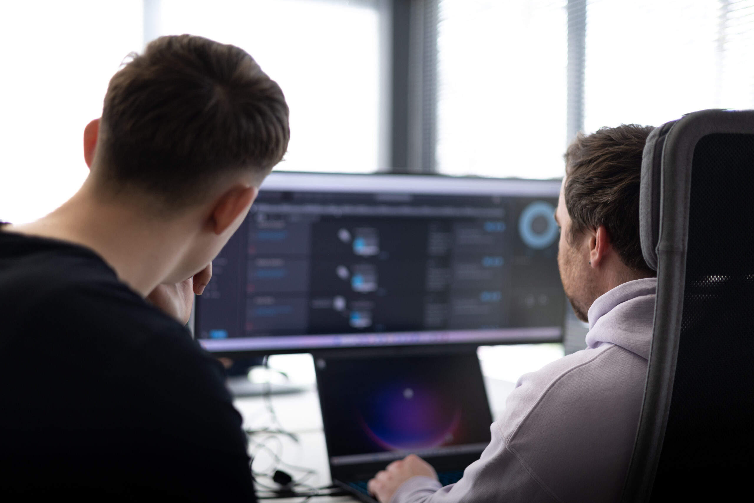 Two analysts reviewing a detection dashboard together during an incident